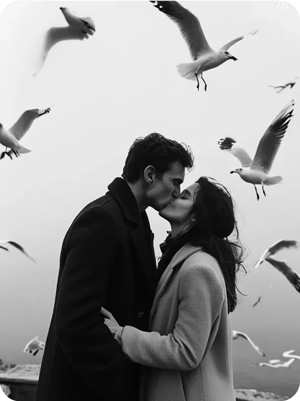 Intimate black and white kiss with seagulls flying nearby